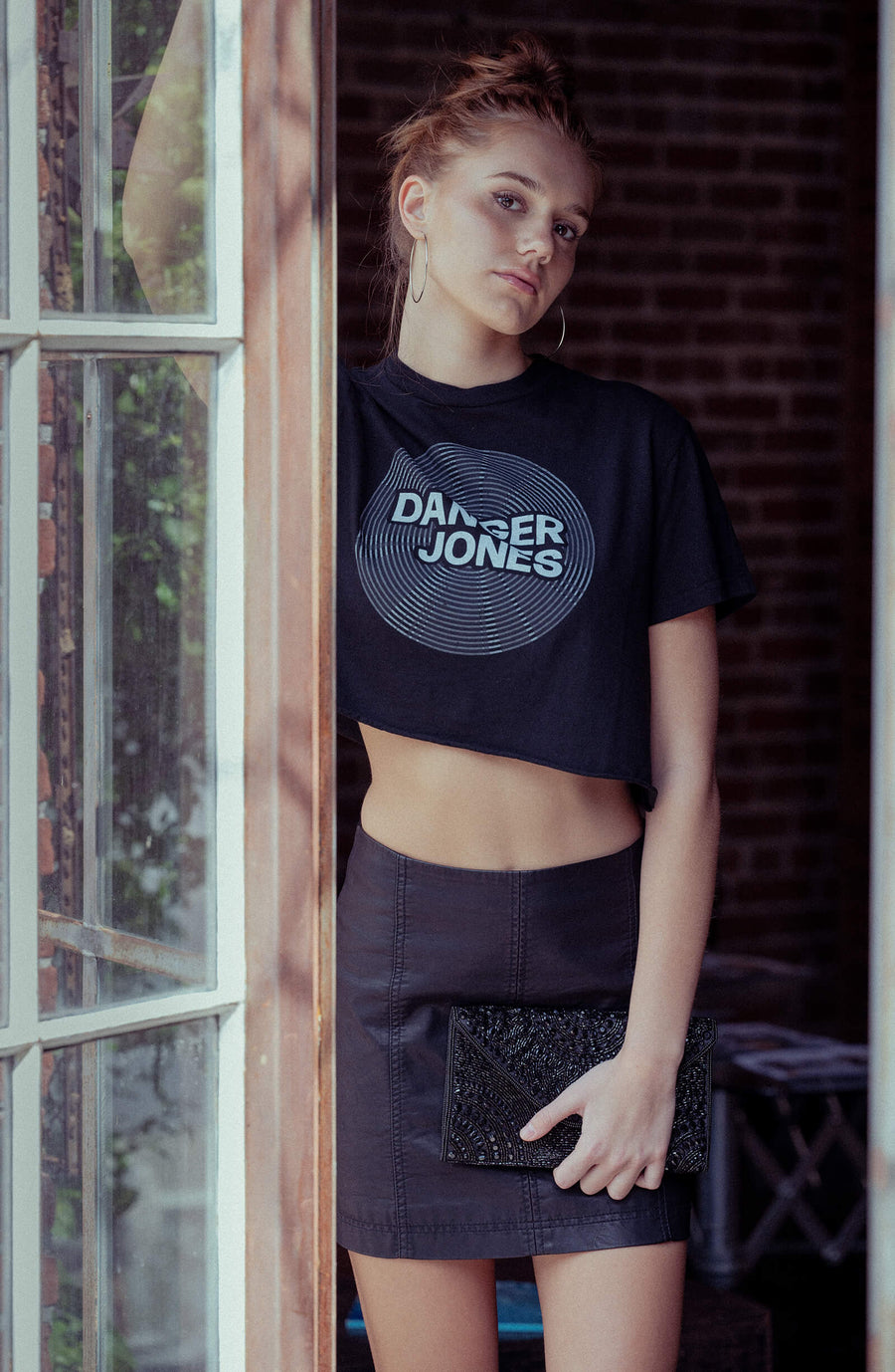 Model standing in a doorway wearing a Danger Jones Vinyl Crop Top